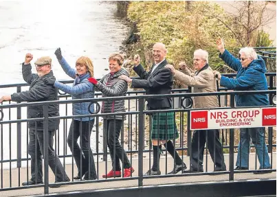  ?? Pictures: Steve MacDougall. ?? Locals, including a kilted Rev Mike Erskine, are the first to cross one of the two new bridges in Alyth town centre.