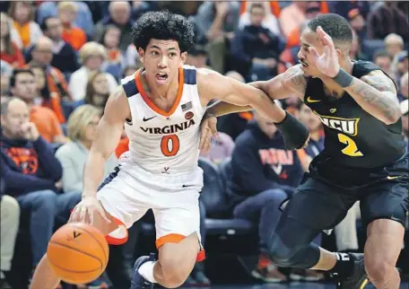  ?? Ryan M. Kelly Getty Images ?? KIHEI CLARK’S heads-up pass to teammate Mamadi Diakite for a game-tying basket kept Virginia alive in the regional final.