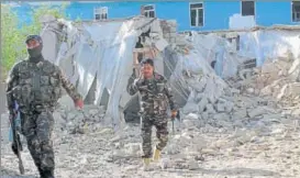  ?? AP ?? Security forces inspect an explosion site in Lashkar Gah, capital of southern Helmand province.