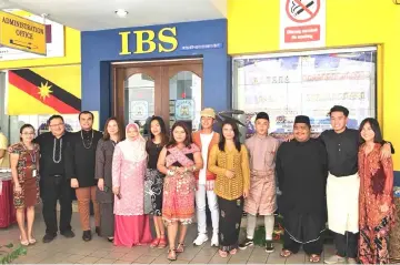  ??  ?? Hii (second left) joins IBS College students and staff – many of whom are donning traditiona­l attire – in a photo-call.