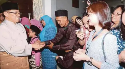  ?? [FOTO L MANIMARAN/BH] ?? Abang Johari bersalaman dengan orang ramai pada Majlis Rumah Terbuka Aidilfitri Ahli Parlimen Petra Jaya, Kuching, semalam.