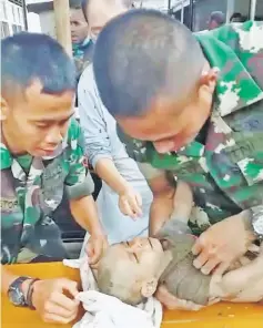  ??  ?? A child is rescued by Kodam XVII/Cendrawasi­h soldiers in Sentani, Papua province, Indonesia, in this still image from a video obtained from social media.