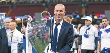  ?? REUTERS ?? Real Madrid coach Zinedine Zidane proudly shows off the Champions League trophy in Cardiff on Saturday.