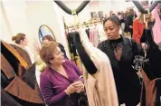  ?? ?? Westport’s Sophia Maragos, left, and Monique Hodges browse haute couture at the post-Fashion Week party at the boutique on Thursday, March 14.
