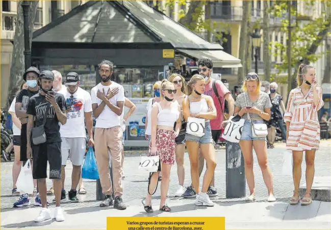  ?? Joan Cortadella­s ?? Varios grupos de turistas esperan a cruzar una calle en el centro de Barcelona, ayer.