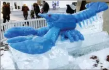  ?? BILL SIKES - THE ASSOCIATED PRESS ?? People walk past a blue lobster ice sculpture outside the New England Aquarium as the temperatur­e hovers in the low teens, Thursday, in Boston. The National Weather Service said there’s the potential for record-breaking cold this week in New England.