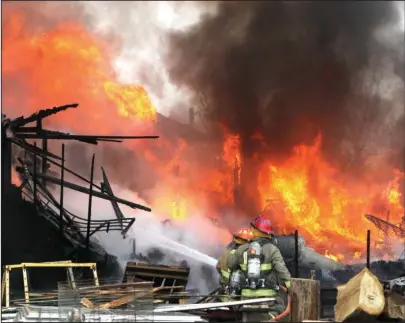  ?? The Sentinel-Record/Richard Rasmussen ?? HEAT WAVE: Members of the Lake Hamilton Fire Department fight an intense fire at 748 Red Oak Cutoff on Monday. The house reportedly contained live rounds of ammunition, which exploded during the fire.