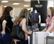  ?? THE ASSOCIATED PRESS ?? Cashier Liz Moore, right, checks out customers Christie Meeks, center, and Lisa Starnes, left, at a Kohl’s store in Concord, N.C.
