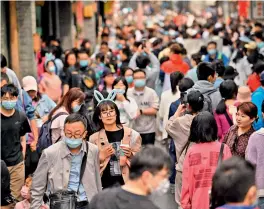  ?? — AFP ?? People walk through an alley near Houhai lake in Beijing during the Labour Day holidays, which take place from May 1 to May 5, on Tuesday.