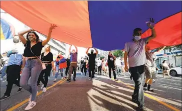  ?? Myung J. Chun Los Angeles Times ?? PROTESTERS CARRY a giant f lag Sunday on Wilshire Boulevard in support of Armenia in its warring with Azerbaijan. About 35,000 people marched to the Turkish Consulate, decrying Turkey’s support for Azerbaijan.