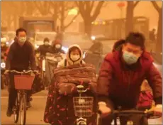  ?? FENG YONGBIN / CHINA DAILY ?? Commuters brave a sandstorm in Beijing on March 15. The capital, together with many regions in northern China, experience­d the strongest sandstorm in nearly a decade, according to the National Meteorolog­ical Center.