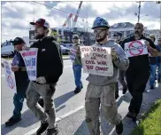  ?? JOSH REYNOLDS / AP ?? Justin Paetow (center), a tin shop worker at Bath Iron Works, takes part in a demonstrat­ion against the company’s COVID-19 vaccine mandate outside the shipyard on Friday in Bath, Maine.