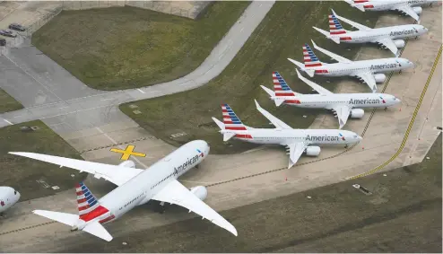  ?? NICK OXFORD / REUTERS FILES ?? American Airlines planes are parked due to flight reductions made to slow the spread of coronaviru­s disease (COVID-19), at Tulsa Internatio­nal
in Tulsa, Okla. The planes on the right are Boeing 737 Max aircraft, parked since their grounding by regulators over flight safety issues.