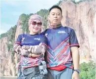  ??  ?? DAYANG Salmah (kiri) bersama suaminya yang juga pegawai bomba Sandakan, yang turut menyertai rombongan hiking dan mendaki bukit Bukit Berhala.