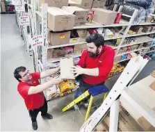  ?? DAN JANISSE ?? Youth Job Connection grads Mike Brewer, left, and Brandon Wall stock warehouse shelves Wednesday at Canadian Tire.