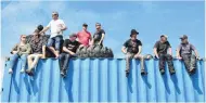  ??  ?? Vantage point . . . Canny spectators watch racing from a shipping container.