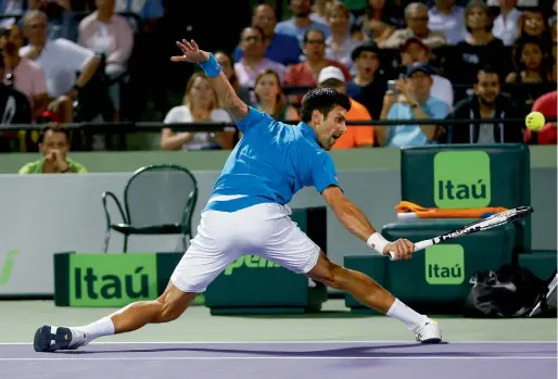  ??  ?? Novak Djokovic stretches to play a return to Tomas Berdych.