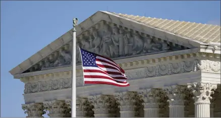  ?? PATRICK SEMANSKY ?? FILE - In this Nov. 2, 2020, file photo an American flag waves in front of the Supreme Court building on Capitol Hill in Washington. The Supreme Court is hearing arguments over whether the Trump administra­tion can exclude people in the country illegally from the count used for divvying up congressio­nal seats.