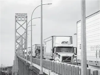  ?? Cole Burston / Bloomberg ?? Commercial trucks drive across Ambassador Bridge on the Canada-U.S. border in Windsor, Ontario. Any omission of Canada in a new NAFTA-like deal troubles economists.