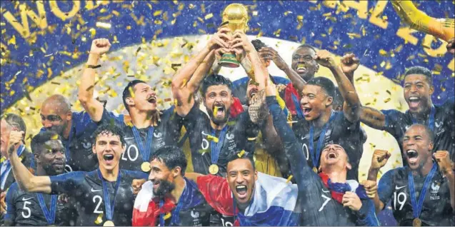  ?? GETTY IMAGES ?? ■ Surrounded by teammates, France’s Olivier Giroud holds the World Cup trophy at the Luzhniki Stadium in Moscow on Sunday. France ended a 20year wait for their second World Cup triumph in what was their thirdever final.