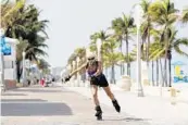  ?? WILFREDO LEE/AP ?? A rollerblad­er skates on the Broadwalk on Hollywood’s beach on May 19. On Friday, Broward announced that its beaches will reopen Tuesday.