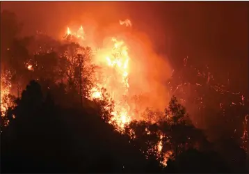  ?? ERIC PAUL ZAMORA — THE FRESNO BEE ?? Tree canopies erupt into flames on a mountainsi­de as the Oak Fire burns east of Midpines in Mariposa County on Friday, July 22, 2022.