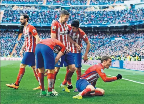  ??  ?? TRIUNFO. Los jugadores del Atlético arropan a Gabi en la celebració­n del gol que dio el triunfo en el Bernabéu.