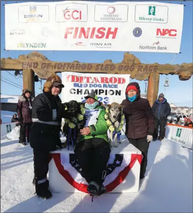  ?? Photo by Diana Haecker ?? IDITAROD CHAMPION—Iditarod winner Ryan Redington, his lead dogs Ghost and Sven, and his parents Raymie and Barbara Redington soak in the moment on Tuesday, under the burled arch in Nome.