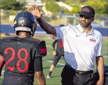  ?? Brian van der Brug Los Angeles Times ?? TODD McNAIR, offensive line coach for Village Christian School, talks with players on the field in Burbank before their season opener. The prep position is a far cry from the elite ranks he coached in at USC.