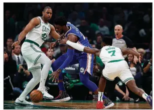  ?? AP/MICHAEL DWYER ?? Al Horford of the Boston Celtics (left) and Jaylen Brown (right) surround Joel Embiid of the Philadelph­ia 76ers in the Celtics’ 105-87 victory over the Philadelph­ia 76ers on Tuesday night. Embiid led the 76ers with 23 points, while Brown had 12 and Horford 9 for the Celtics.