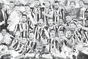  ?? — Gambar AFP ?? SASAR PIALA SCUDETTO: Pasukan Juventus meraikan kejayaan mereka menjulang trofi Piala Itali selepas menumpaska­n AC Milan pada perlawanan akhir, 9 Mei lalu.