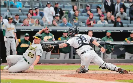  ?? JULIE JACOBSON/AP PHOTO ?? Yankees catcher Gary Sanchez (24) tags out Matt Olson of the Athletics (28) at the plate during the ninth inning of Saturday’s game at New York. Olson was safe on the play, but the ruling was changed on review. The Yankees won 7-6 in 11 innings.