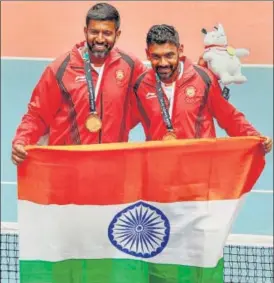  ?? AFP ?? India's gold medallists Rohan Bopanna (left) and Divij Sharan (right) pose for photograph­ers after their win over Kazakhstan’s Aleksandr Bublik and Denis Yevseyev in Friday’s final in Palembang.