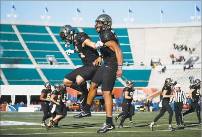  ?? Joe Robbins / Getty Images ?? Wake Forest’s Jamie Newman, right, celebrates with Sage Surratt after scoring the winning touchdown against Memphis on Saturday.