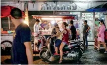  ??  ?? This photo taken on April 17, 2017 shows people waiting to pick up food from a street stall in the Phrakanong district of Bangkok.