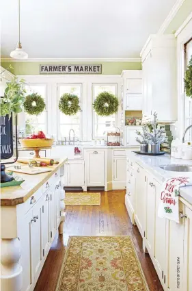  ?? ?? (above, right) Windows are the perfect spot to display wreaths. Homeowner Leslie Saeta has a wreath hanging in every window of her kitchen for a festive touch that won’t interfere with the functional­ity of the space.
