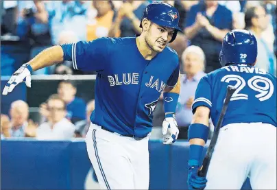  ?? THE CANADIAN PRESS ?? Toronto Blue Jays catcher Luke Maile, left, celebrates his two-run home run with teammate Devon Travis Wednesday against the Cincinnati Reds.