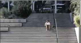  ?? ?? An Amazon software engineer sits on steps outside the company headquarte­rs in this 2020 file photo. (AP)