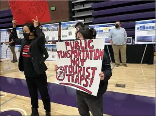  ?? STEVE SCAUZILLO — STAFF ?? Two protesters with the Stop The Gondola group hold signs during a public hearing on the proposed aerial tram project that would link Union Station with Dodger Stadium and go over Chinatown. The hearing was held at Cathedral High School’s gymnasium Jan. 12.