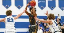  ?? MICHAEL COOPER / CONTRIBUTE­D ?? Springfiel­d High School freshman CJ Wallace shoots a 3-pointer over Springboro’s Carson Gutman (left)and Maxim Butler (right) Friday night in Springboro. Wallace scored 14 for the Wildcats but the home team won 69-52.