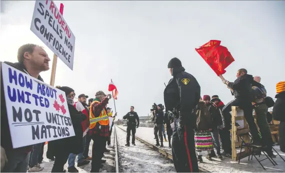  ?? LIAM RICHARDS ?? Saskatoon Police monitor as counter-protesters confront a group of Indigenous youth and allies demonstrat­ing in solidarity with the Wet’suwet’en Nation hereditary chiefs along a section of railway in between 20th Street West and 21st Street West on Avenue I on Saturday.