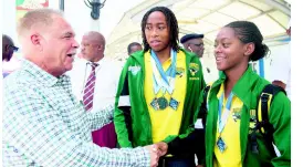  ??  ?? Martin Lyn (left) President, Amateur Swimming Associatio­n of Jamaica, congratula­tes Karci Gibson (right) and Brianna Anderson, who were among the Jamaican team members, who returned to the island yesterday at the Norman Manley Internatio­nal Airport, from the 2019 Carifta Swimming Championsh­ips in Barbados.