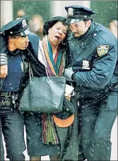  ?? ?? Aiding the injured: Police get a woman away from the scene at the World Trade Center 30 years ago.