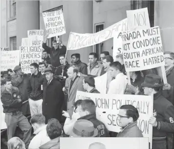  ??  ?? A Record photograph­er covered a march in 1960 when scores of protesters moved down King Street and demonstrat­ed on the steps of City Hall. They called for an end to Apartheid in South Africa. Just before Christmas 1953, The Record published a story and photo about a butchering bee at the St. Agatha Orphanage.Simon Dietner, wearing an apron and sharpening a knife, worked with other butchers to make sure the children had enough meat for the winter.