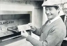  ?? FOTO: ULLSTEIN ?? Tatort Enfield: Der britische Schauspiel­er Reg Varney zieht am 27. Juni 1967 eine Pfund-Note aus dem weltweit ersten Geldautoma­ten.