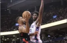  ?? CHRIS YOUNG — THE CANADIAN PRESS VIA AP ?? Toronto Raptors’ Norman Powell, left, shoots on Philadelph­ia 76ers’ Joel Embiid, right, during the second half of an NBA basketball game in Toronto on Saturday.