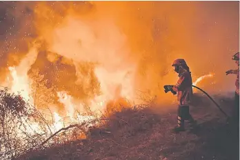  ??  ?? Firefighte­rs try to extinguish a fire in Cabanoes near Louzan as wildfires continue to rage in Portugal. At least 27 people have died in fires which have ravaged forests in the north and centre of the country over the past 24 hours. — AFP photo