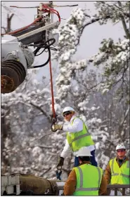  ?? (Democrat-Gazette file photo) ?? A utility crew works on repairs in Little Rock on Dec. 27, 2012, after a snowstorm that left hundreds of thousands of homes and businesses without power.