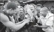  ?? Rich Pedroncell­i Associated Press ?? ANDRE CHEVALIER hands the state championsh­ip trophy to his players after defeating Sheldon 75-62.