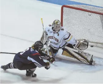  ?? STAFF PHOTO BY NICOLAUS CZARNECKI ?? LAMPLIGHTE­R: UConn forward Natalie Snodgrass slips a shot past Boston College Eagles goaltender Katie Burt yesterday at Matthews Arena.